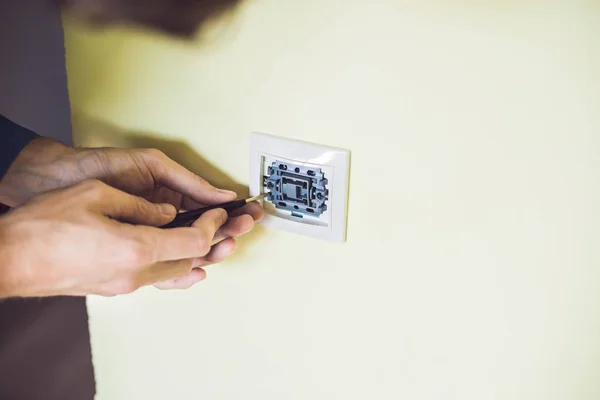 Eletricista instalando um interruptor elétrico — Fotografia de Stock