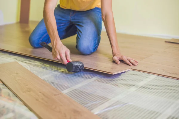 Uomo l'installazione di nuovi pavimenti in laminato — Foto Stock