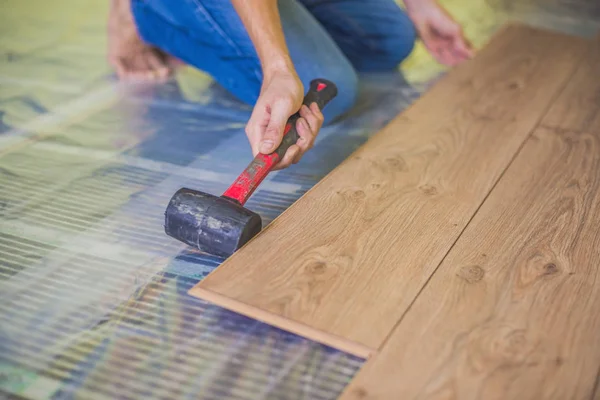 Uomo l'installazione di nuovi pavimenti in laminato — Foto Stock