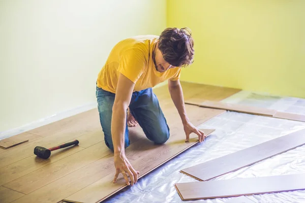 Uomo l'installazione di nuovi pavimenti in laminato — Foto Stock