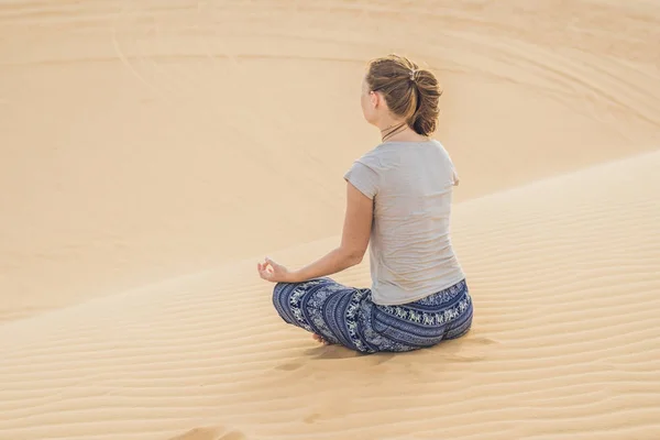 Jonge vrouw mediteren in de woestijn — Stockfoto