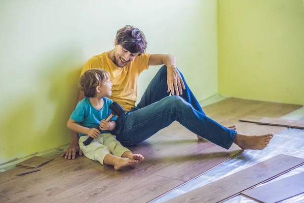 Padre e hijo instalando pisos laminados . — Foto de Stock