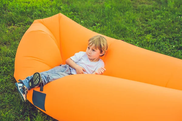 Boy resting on an air sofa — Stock Photo, Image
