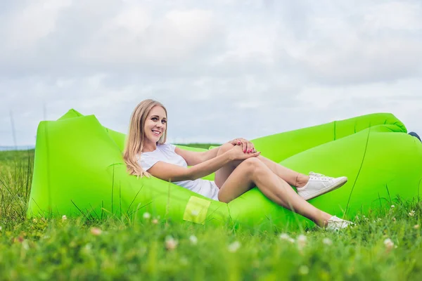 Mujer joven descansando en un sofá de aire — Foto de Stock