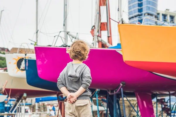 Pojken tittar på yachter och segelbåtar — Stockfoto