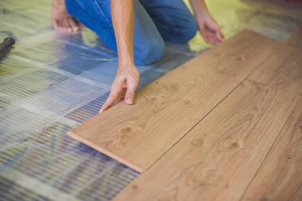 Hombre instalación de pisos laminados de madera nueva —  Fotos de Stock