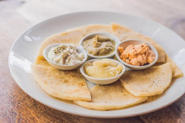Pieces of pita bread and four kinds of Greek sauces\ — Φωτογραφία Αρχείου
