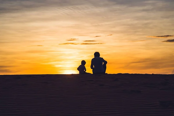 Padre e hijo en el desierto rojo al amanecer — Foto de Stock