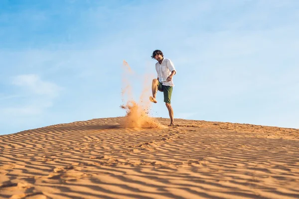 Bir adam bir kırmızı çölde kum tekme atıyor — Stok fotoğraf