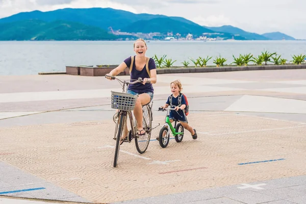 Happy family is riding bikes outdoors