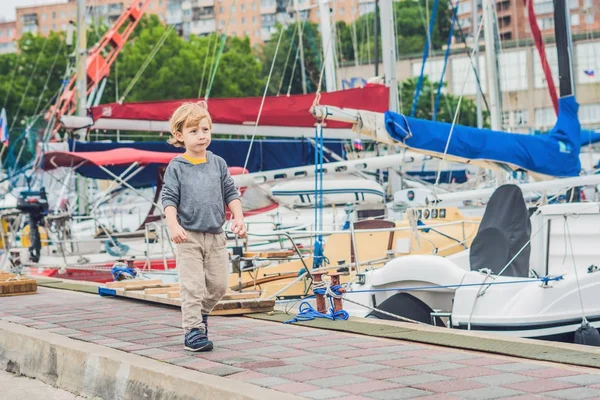 Хлопчик дивиться на яхти і вітрильники — стокове фото