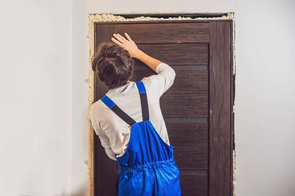 Молодой мастер устанавливает дверь — стоковое фото