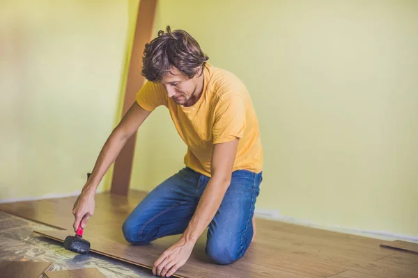 Man installing new wooden laminate flooring — Stock Photo, Image
