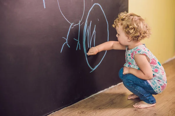 Маленькая девочка рисует мелом — стоковое фото