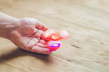 Adam el el spinner veya topluca spinner ahşap arka plan üzerinde tutarak.