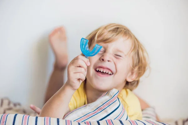 Niño de tres años muestra entrenador miofuncional para iluminar la boca — Foto de Stock