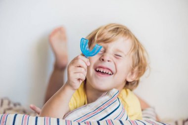 Three-year old boy shows myofunctional trainer to illuminate mouth clipart