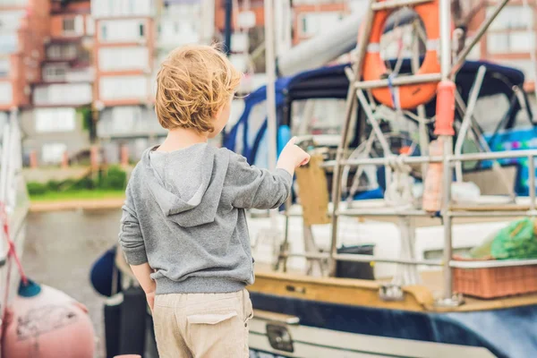 Хлопчик дивиться на яхти і вітрильники — стокове фото