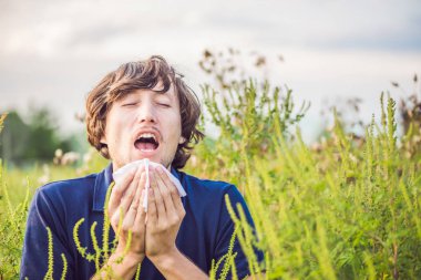 Young man sneezes because of an allergy clipart