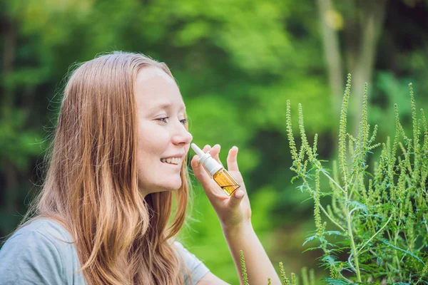 Mujer joven utiliza un aerosol de una alergia — Foto de Stock