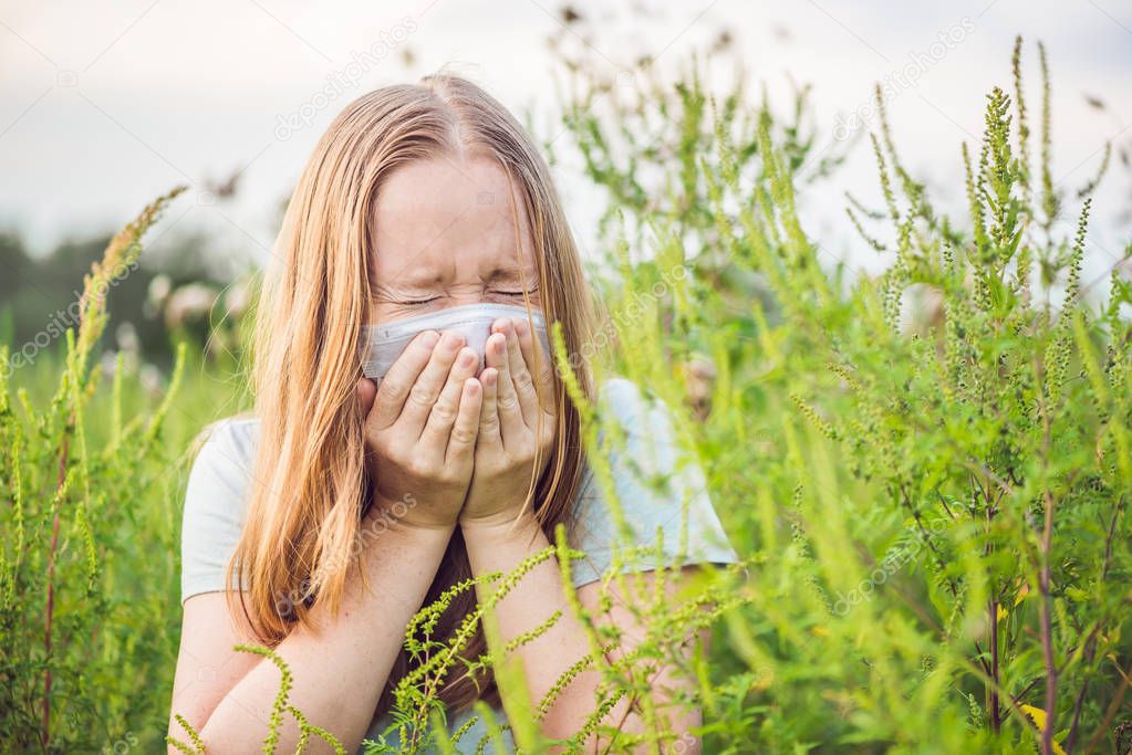 Young woman sneezes because of an allergy