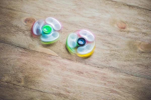 Ahşap arka plan üzerinde renkli topluca spinners stres giderici oyuncak.