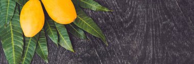 Mango ve mango yaprakları üzerinde ahşap arka plan