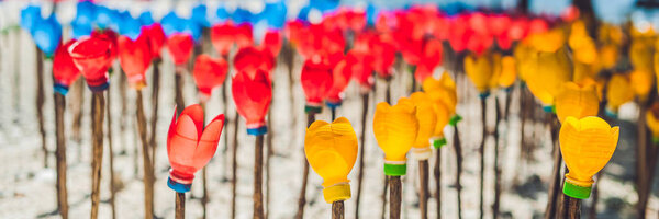 Recycled colorful plastic flower. Waste recycling concept Long Format.