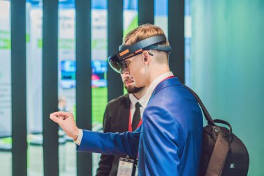 Vladivostok, Rusya - 7 Eylül 2017: genç adam sanal gerçeklik kulaklık veya etrafa ve Microsoft Hololens bir şey dokunmak çalışırken gözlük takıyor. VR
