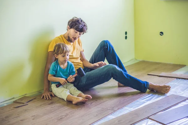 Baba ve oğul yeni ahşap Laminat parke yükleme — Stok fotoğraf