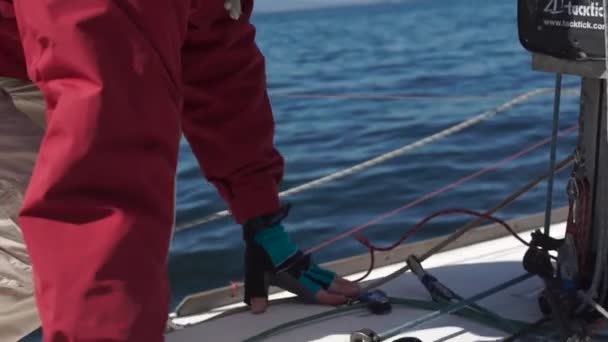 Slowmotion постріл на yachtsman рухається вздовж палубі яхти — стокове відео