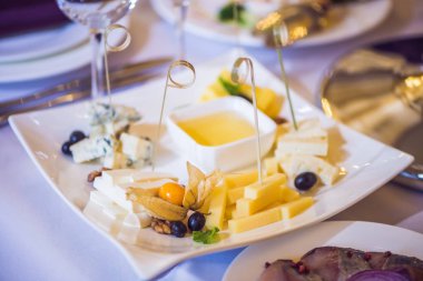 Bal ve peynirler beyaz bir plaka üzerinde