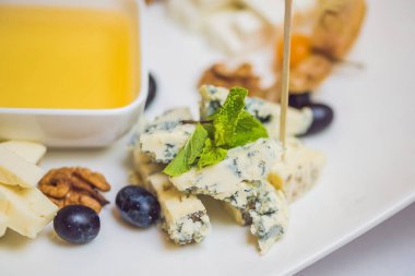 Bal ve peynirler beyaz bir plaka üzerinde