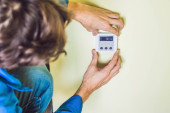 Elektriker installiert ein elektrisches Thermostat 
