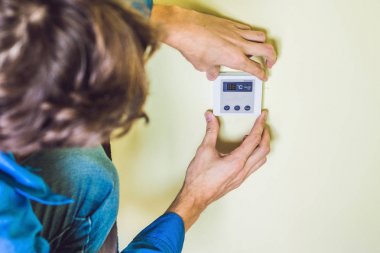 electrician installing an electrical thermostat  clipart