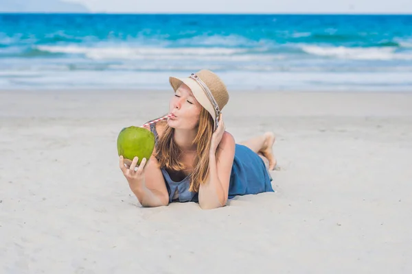 Jovem mulher bebendo leite de coco na praia . — Fotografia de Stock