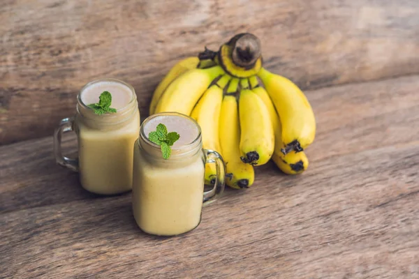 Bananen-Smoothies und Bananen auf altem Holzgrund — Stockfoto