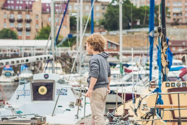 Netter blonder Junge mit Blick auf Yachten und Segelboote — Stockfoto