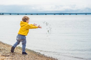 Su deniz taş atan genç çocuk