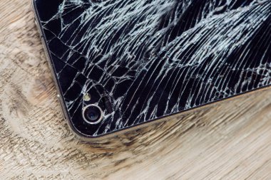 Yünlü bir masada kırık camlı akıllı telefon ekranı..