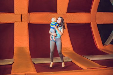 Anne ve oğlu fitness Park'ta bir trambolin üzerinde atlama ve kapalı exersice yapıyor.