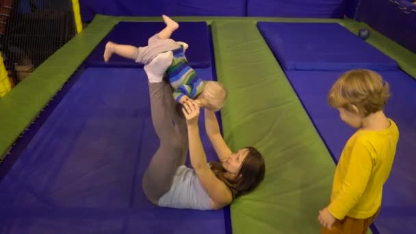 Mother Boys Jumping Trampoline Fitness Park Doing Exercise Indoors — Stock Video