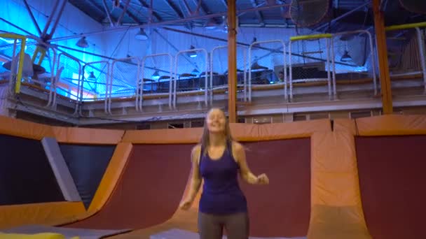 Žena baví uprostřed trampolína — Stock video