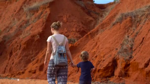 女性と彼女の息子は Mui ベトナムの赤い砂漠の小さな渓谷を歩いて — ストック動画