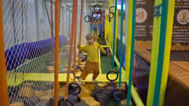 De jongen gaat het hindernissenparcours in de sportclub — Stockvideo