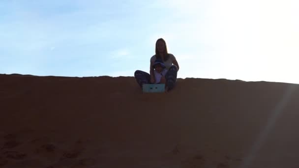 母亲和儿子骑在雪橇上的红色沙漠 — 图库视频影像