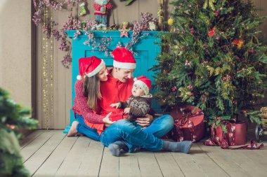Mutlu bir aile Noel kutluyor. Anne, baba ve oğlu Noel süsleri.