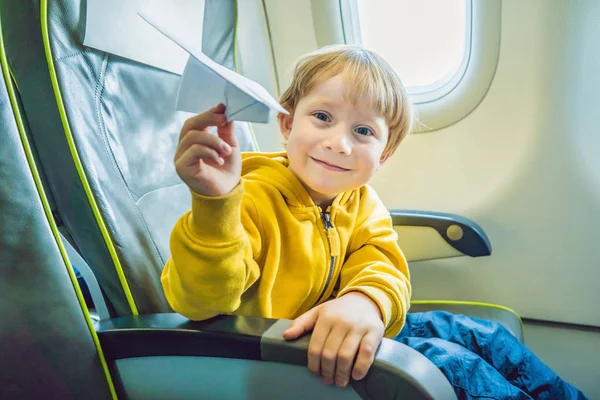 小さな男の子がバカンス飛行商業ジェット機の飛行機の紙飛行機で遊ぶ — ストック写真