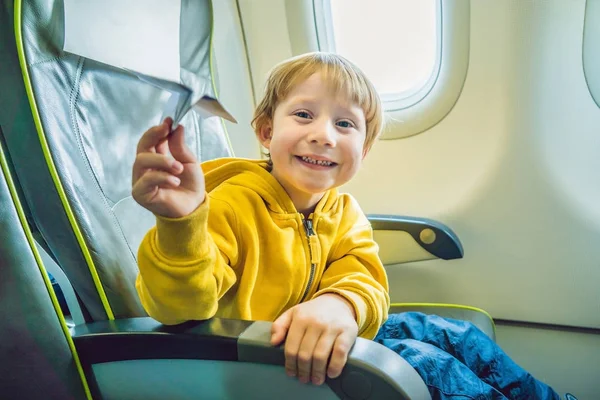 小さな男の子がバカンス飛行商業ジェット機の飛行機の紙飛行機で遊ぶ — ストック写真