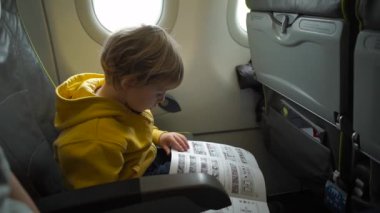 Çocuk izliyor ve uçak gemide uçuş eğlence dinlerken kulaklık ile